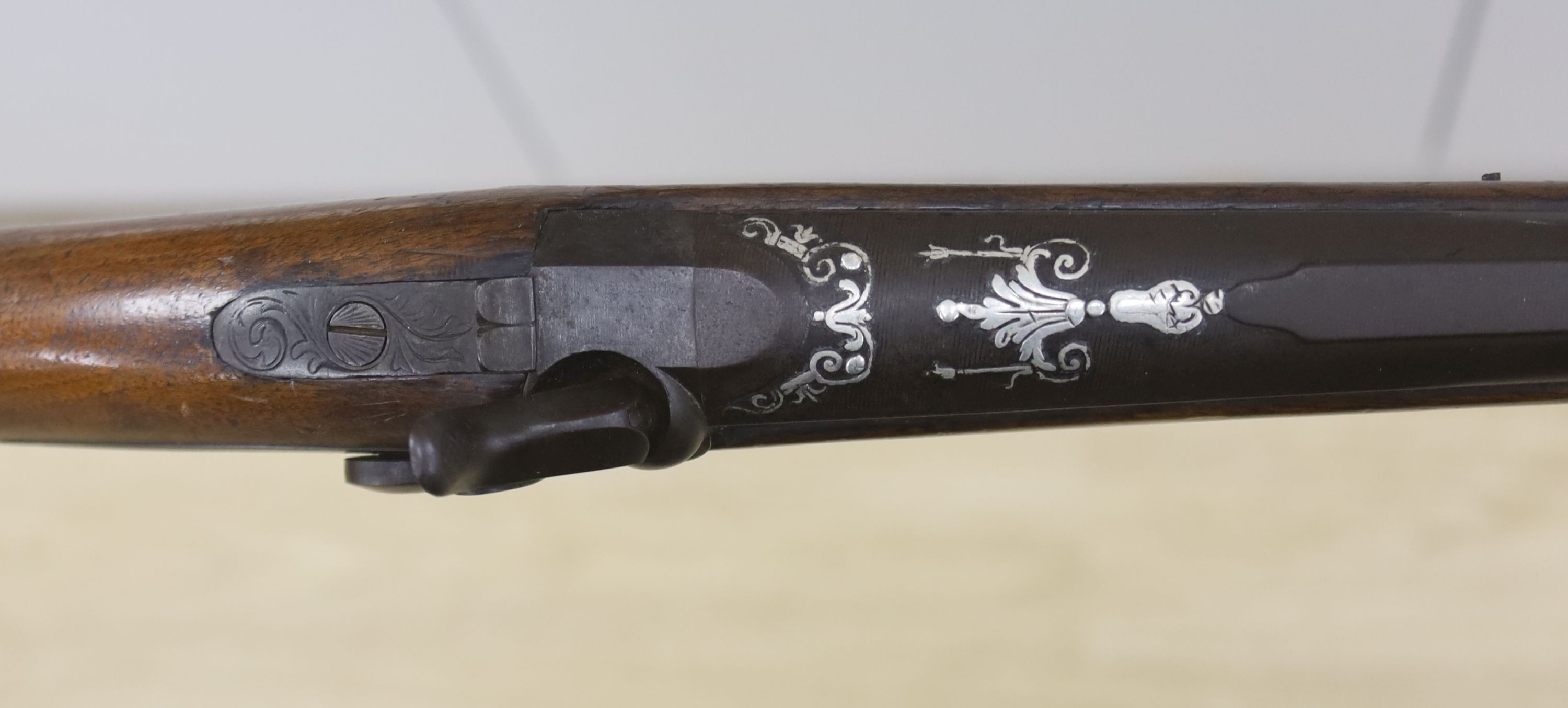 An early 19th century Belgian percussion cap carbine with carved walnut stock and silver inlaid barrel, bears indistinct mark, barrel 38cm, overall length 78cm